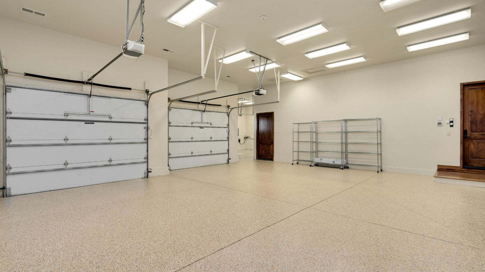 Bright triple garage interior with two ceiling-mounted garage door openers