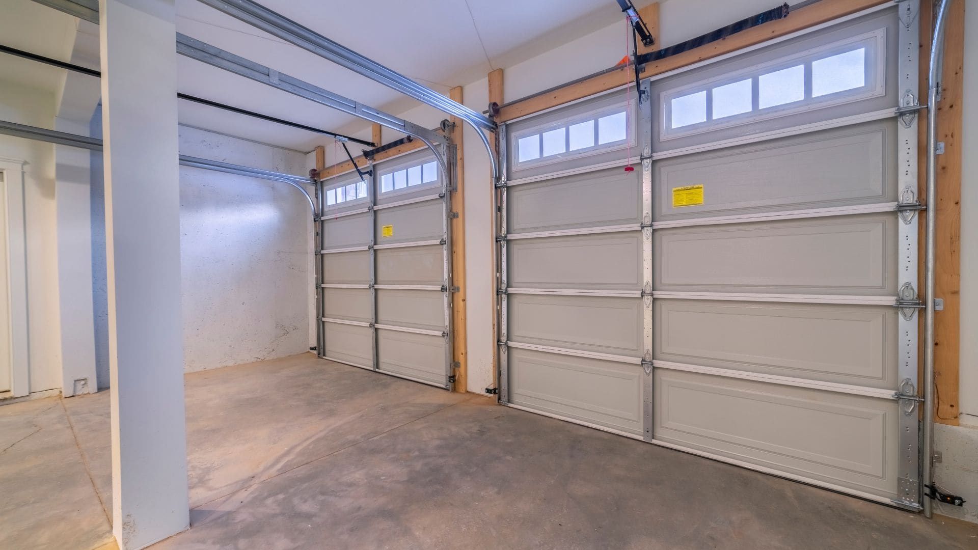 Inside view of two garage doors showing tracks, rollers and hinges
