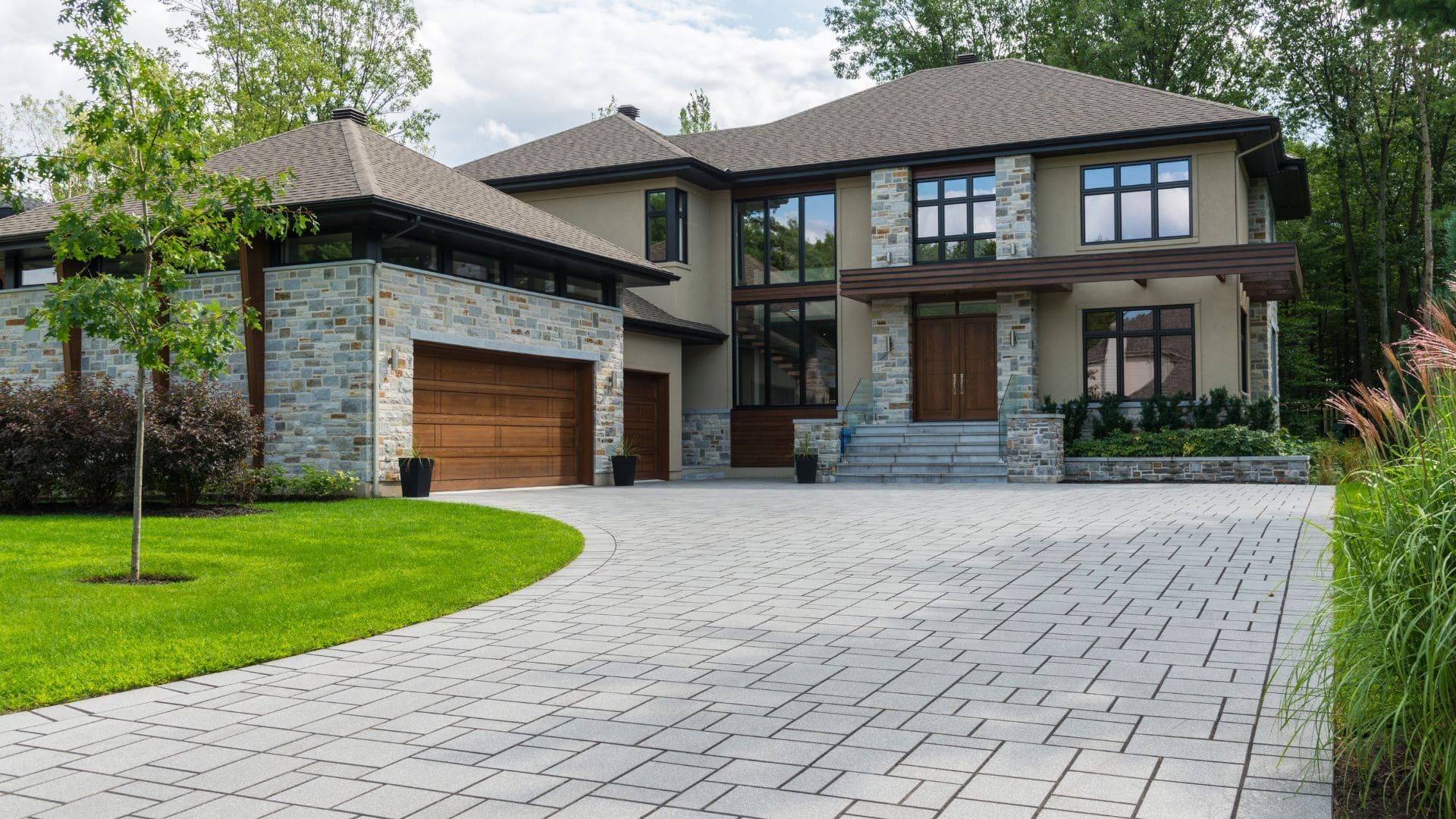Contemporary stone home with wood-look garage doors