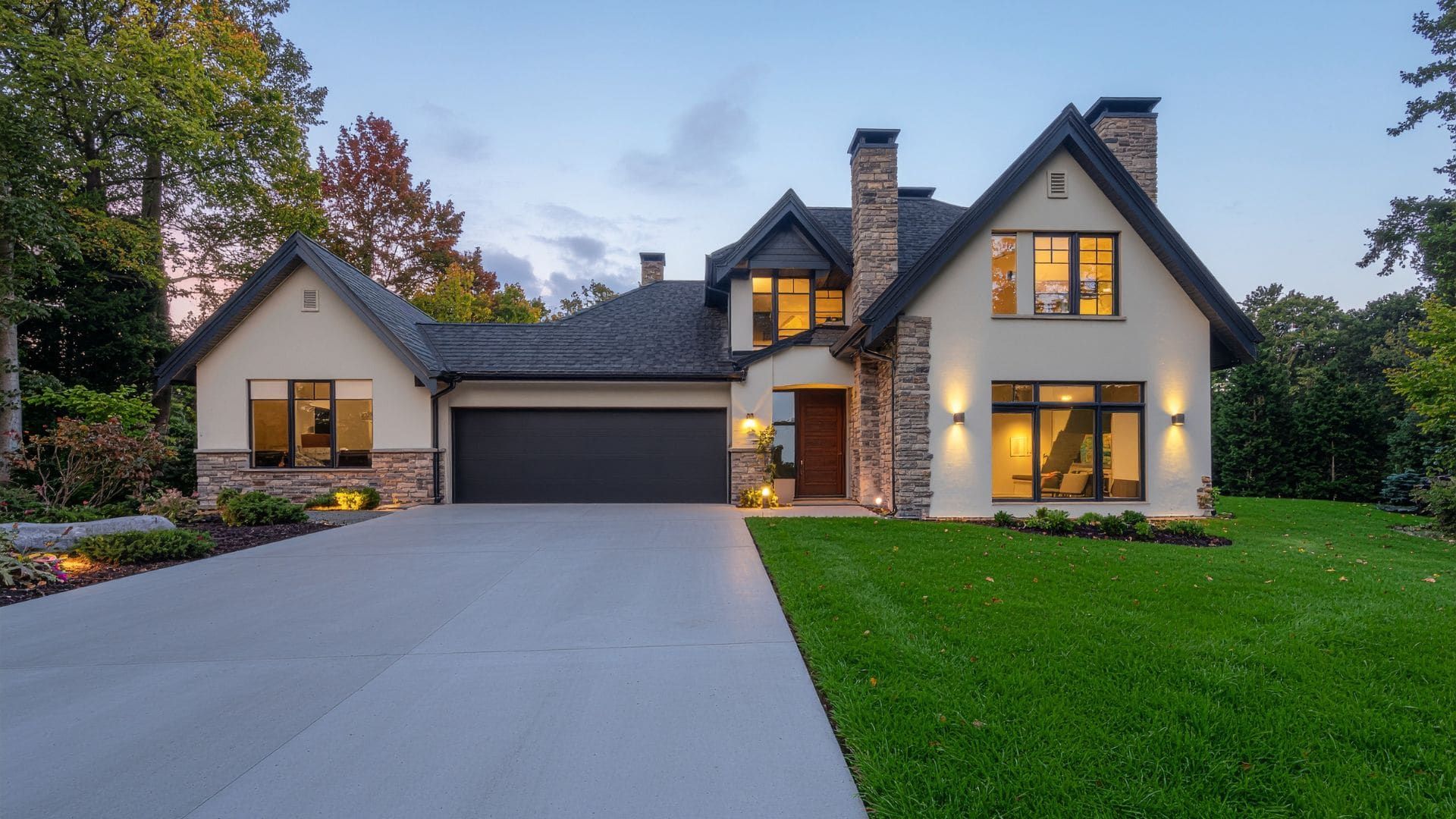 Cottage-style home at dusk with a dark double garage door