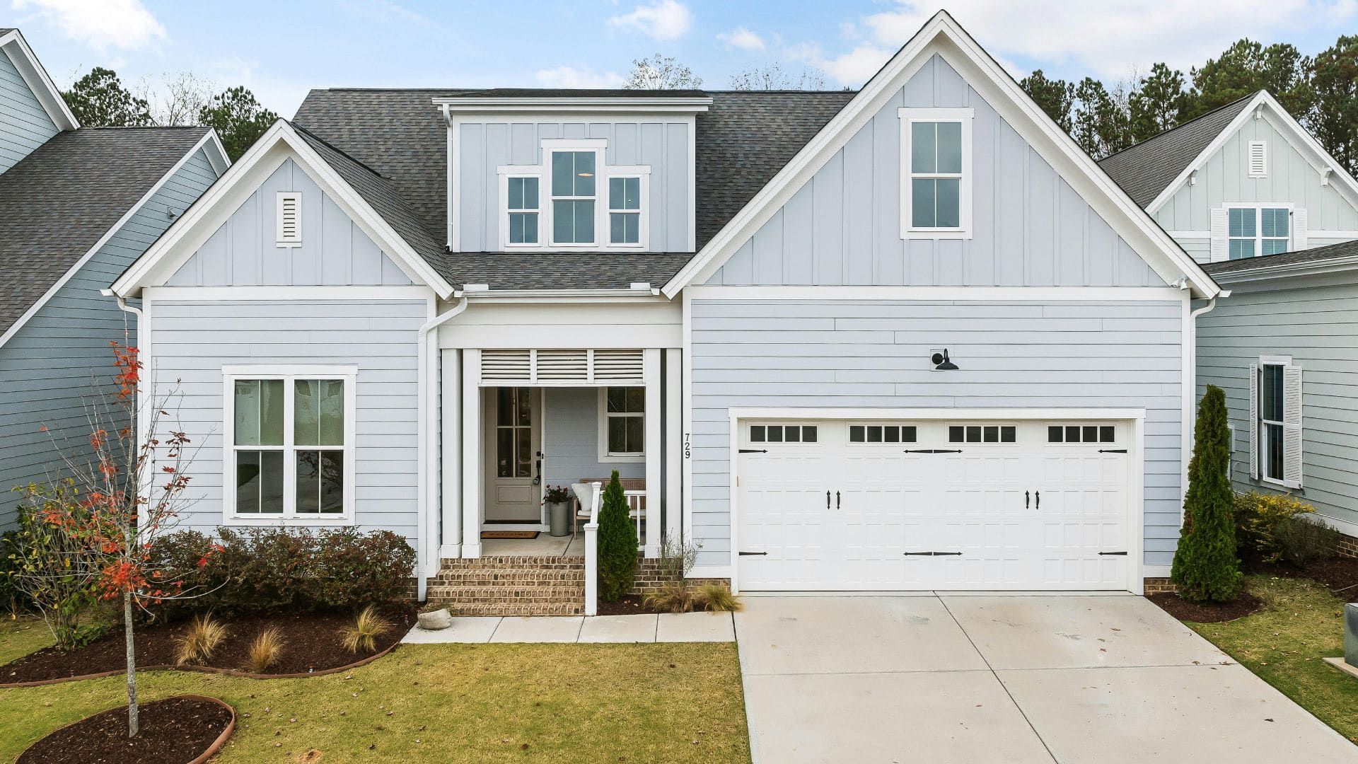 Blue farmhouse-style home with a white carriage garage door