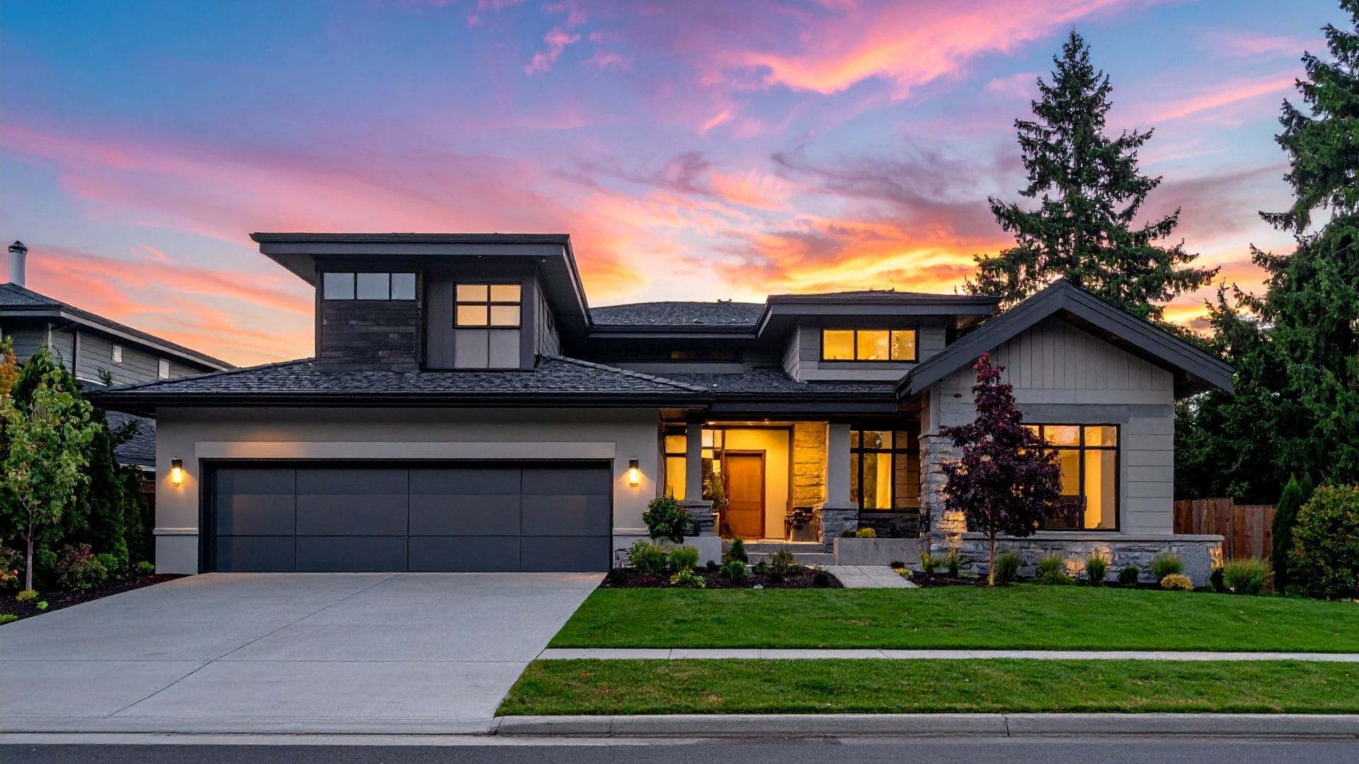 Contemporary home at sunset with a dark flush-panel double garage door